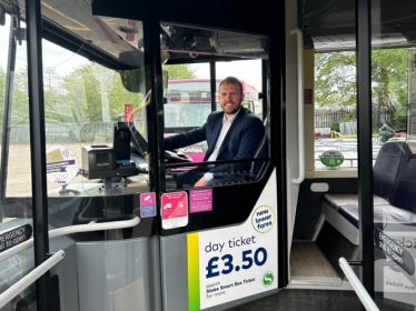 Jonathan sitting behind the wheel of a bus